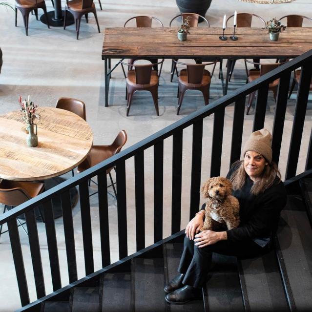 Jessica Eriksson fra Hugo W. Concept sidder på en trappe med udsigt over sit indretningsprojekt